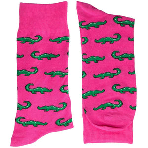 A folded pair of men's hot pink socks with green alligators