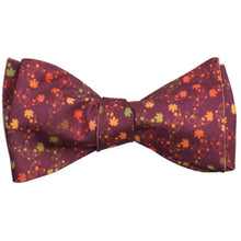 Load image into Gallery viewer, A tied self-tie bow tie with a colorful leaf pattern and burgundy background