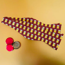 Load image into Gallery viewer, An untied beer mug themed bow tie, in maroon, on a gold background with bottle caps