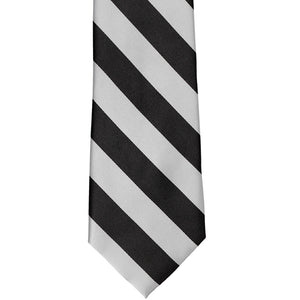 The front of a black and pale silver striped tie, front view