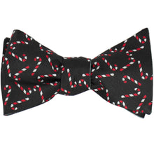 Load image into Gallery viewer, A tied black self-tie bow tie with a candy cane design