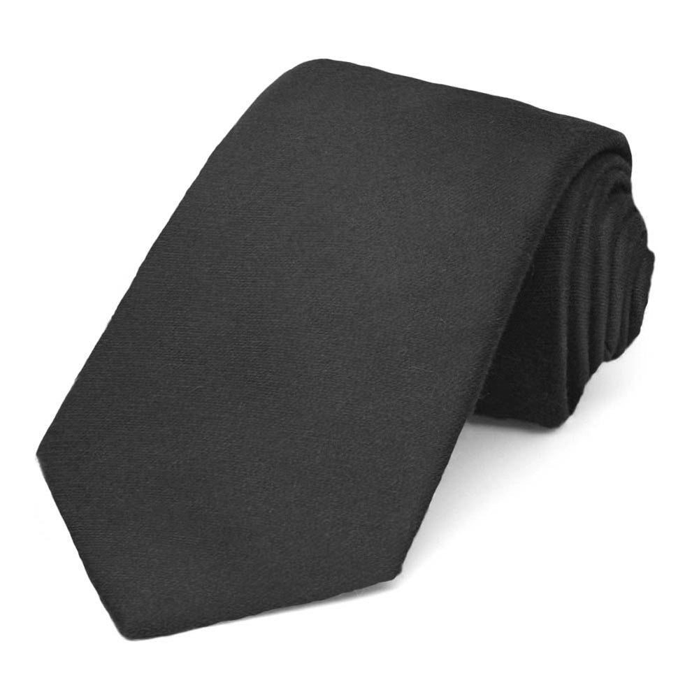 Solid black narrow tie, rolled to show the matte finish