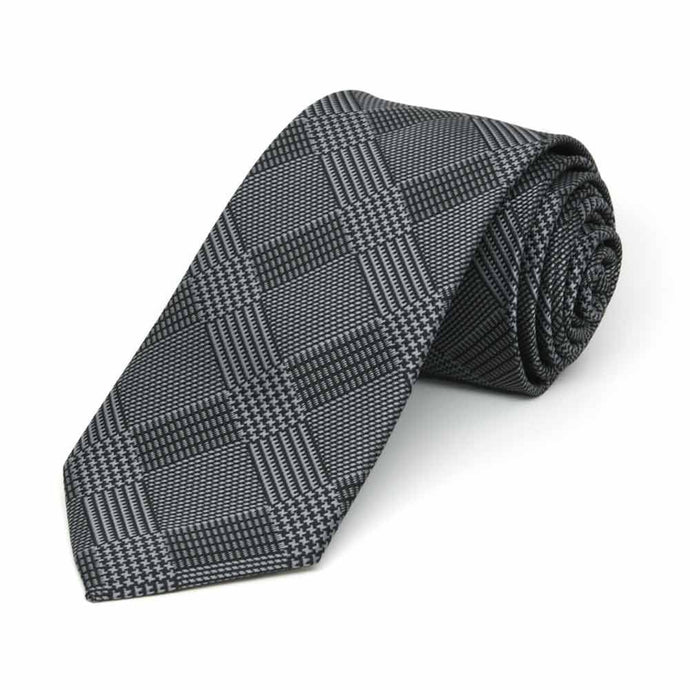 Black and gray plaid slim necktie, rolled to show pattern up close