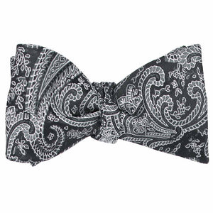 A tied self-tie bow tie in a black and gray paisley pattern
