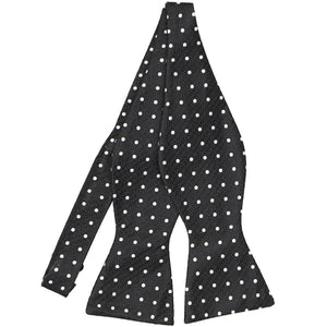 An untied black and white polka dot bow tie