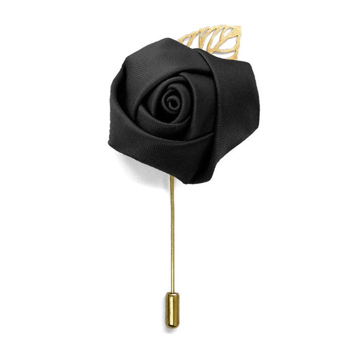 A black flower lapel pin with a gold leaf and pin