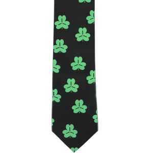 The front of a black slim tie with green shamrocks scattered