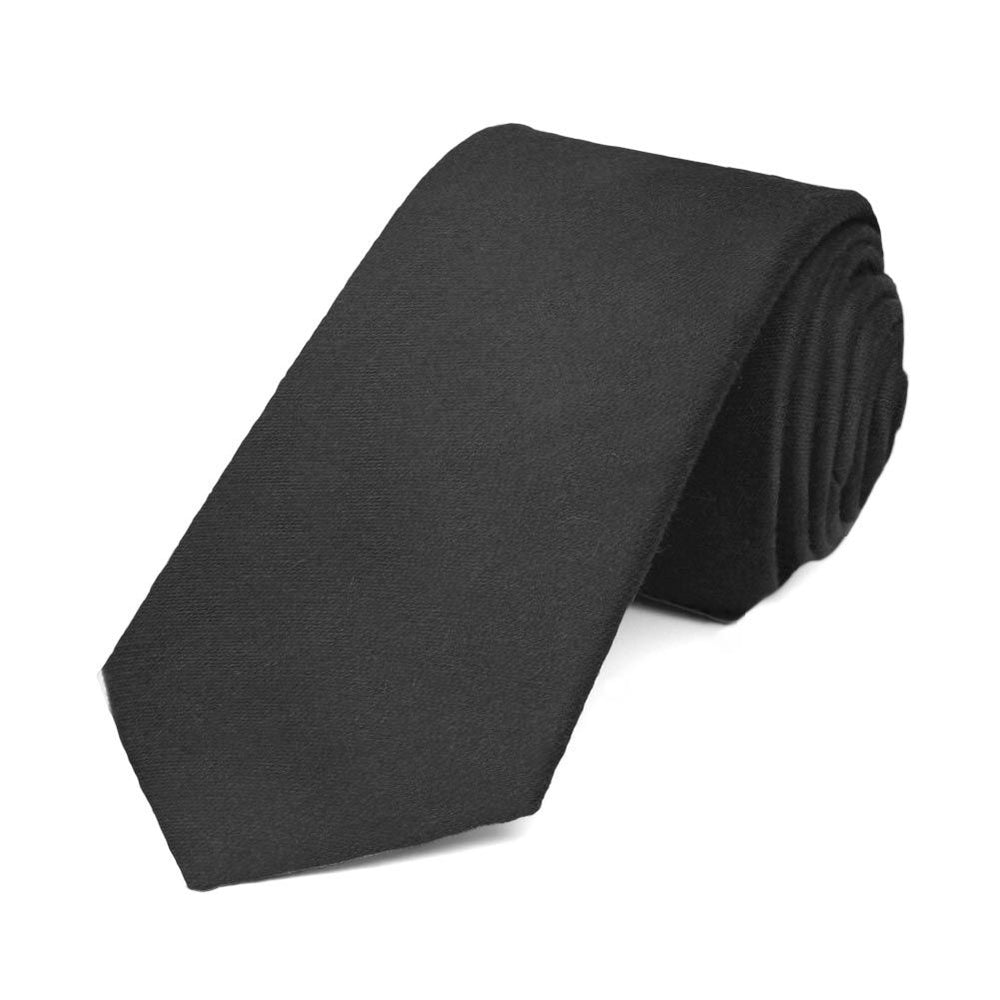 A solid black necktie, rolled to show texture