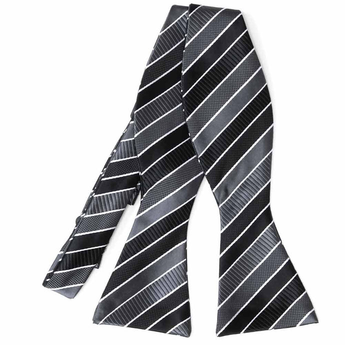 Flat front view of an untied black, gray and white striped self-tie bow tie