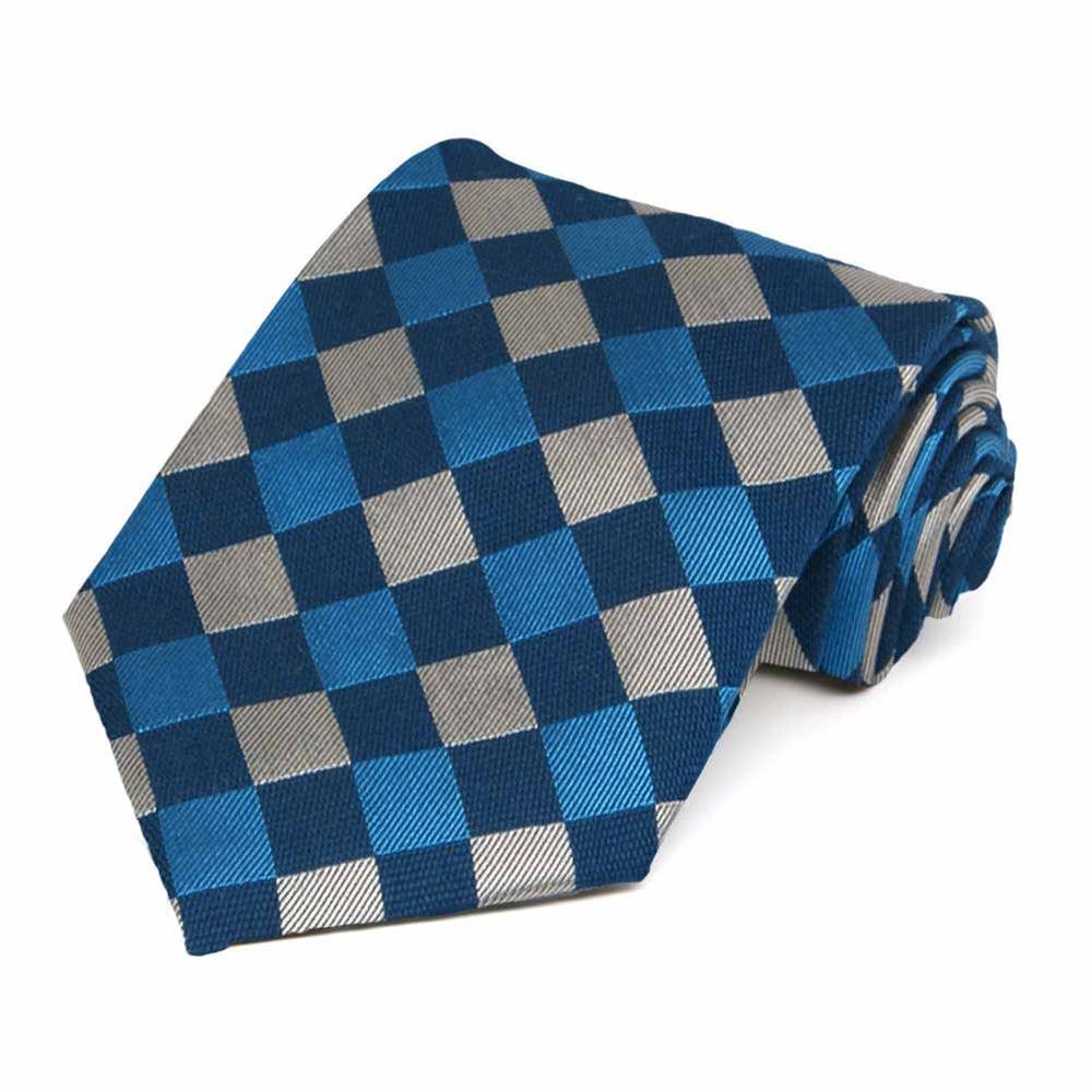 A bright blue, navy blue and silver large print check necktie rolled to show off pattern
