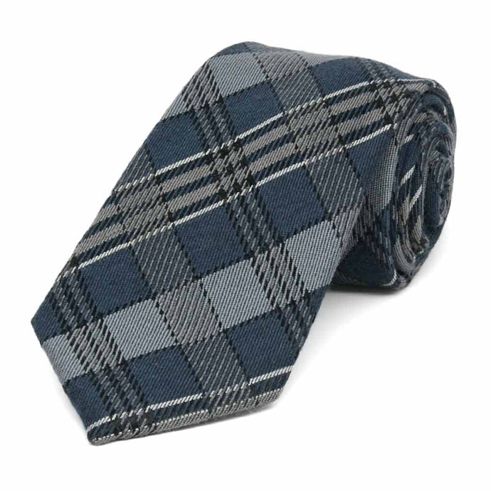 A dark gray and muted blue plaid necktie, rolled to show woolen texture