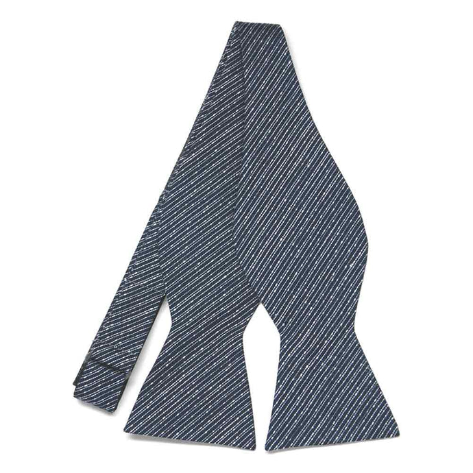 An untied navy blue self-tie bow tie with very thin white diagonal stripes
