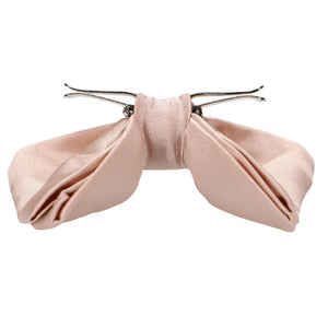 Side view of a blush pink clip-on bow tie, with clips flipped out and ready to wear