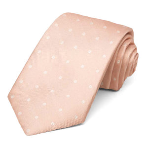 Blush pink necktie with yellow polka dots, rolled to show the woven texture
