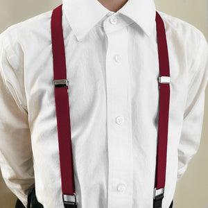 A boy wearing a pair of burgundy suspenders