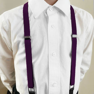 Boy wearing eggplant purple suspenders with a white dress shirt