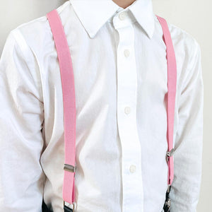 Child wearing a pair of pink suspenders with a white dress shirt
