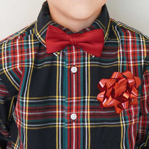 Boy wearing a red bow tie with a tartan shirt and ribbon bow ribbon