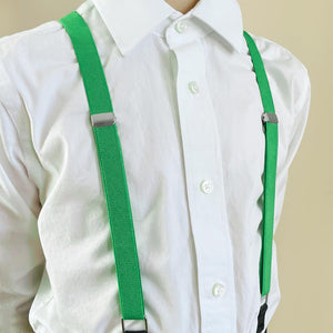A boy wearing a pair of emerald green suspenders with a white dress shirt
