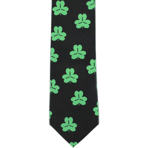 The front of a boys' black and green shamrock tie, laid out flat