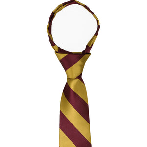 The knot and collar on a maroon and gold striped zipper tie