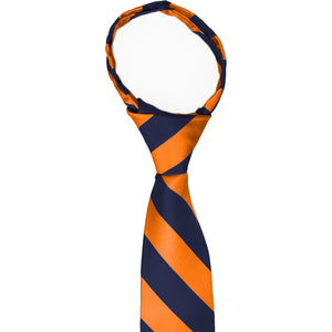 The knot and collar on a navy blue and orange striped zipper tie