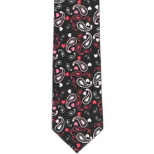 Load image into Gallery viewer, The front view of a boys black tie, lying flat, with a paisley heart pattern