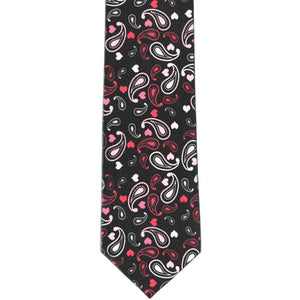 The front view of a boys black tie, lying flat, with a paisley heart pattern