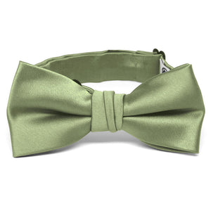 A child-size sage green bow tie in a pre-tied band collar style