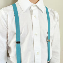 Load image into Gallery viewer, A boy wearing a pair of turquoise blue suspenders with a white dress shirt
