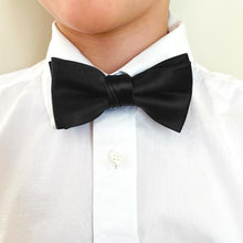 Load image into Gallery viewer, A child wearing a black bow tie with a white dress shirt