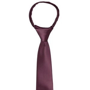 The knot and front of a boys wine zipper tie