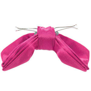 The side of a bright fuchsia clip on bow tie, opened 