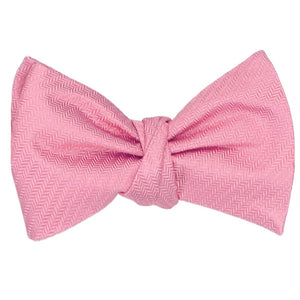 A tied self tie bow tie in a bubblegum pink herringbone pattern