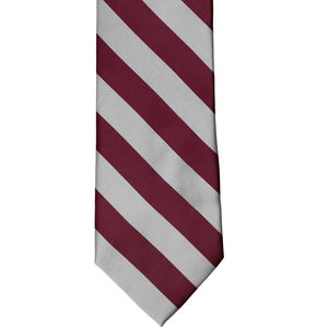 The front of a burgundy and silver striped tie, laid out flat