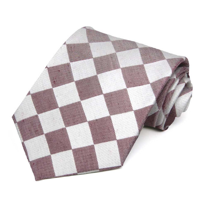 A merlot and white checker pattern necktie, rolled to show the woven texture
