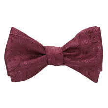Load image into Gallery viewer, A burgundy paisley self-tie bow tie, tied