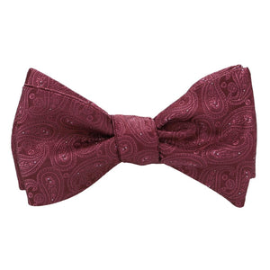 A burgundy paisley self-tie bow tie, tied