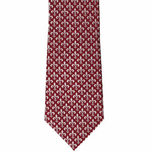 The front of a burgundy tie with a fleur de lis pattern