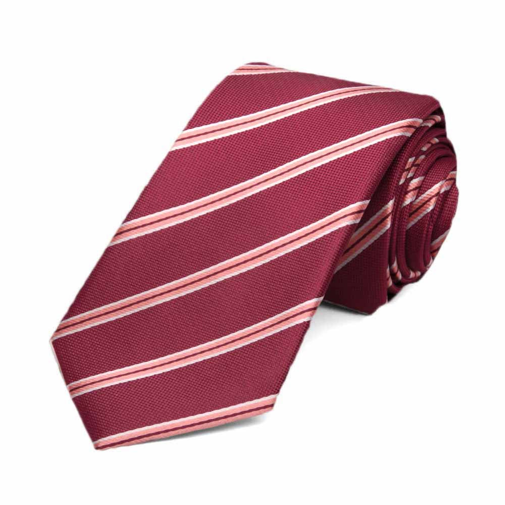 Burgundy and pink striped slim necktie, rolled to show texture of fabric