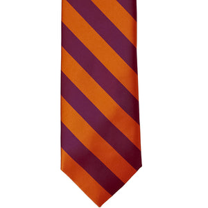 The front of a burnt orange and raspberry striped tie, laid out front