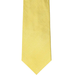 The front of a butter yellow herringbone tie, laid out flat