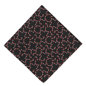 A black pocket square, folded into a diamond, with a candy cane designed scattered across it