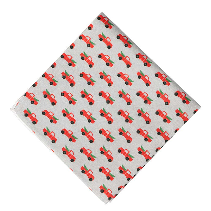 A red Christmas pickup truck pocket square on a gray background, folded into a diamond