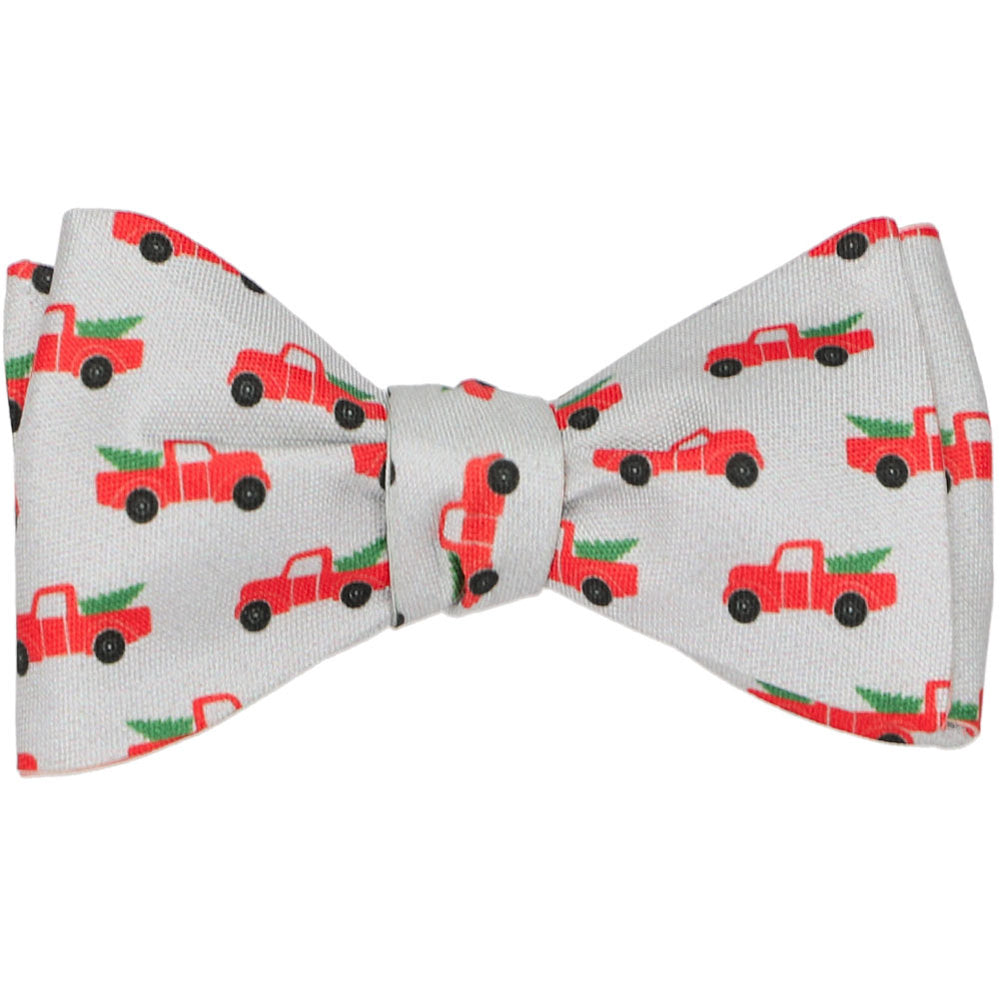 A tied gray bow tie with red Christmas pickup trucks