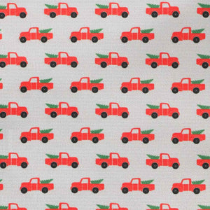 Closeup of a gray background pattern with red Christmas pickup trucks