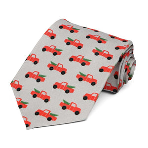 An extra long Christmas tie with red pickup trucks and trees on a gray background