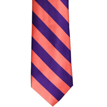 Load image into Gallery viewer, The front of a coral and dark purple striped tie, laid out flat