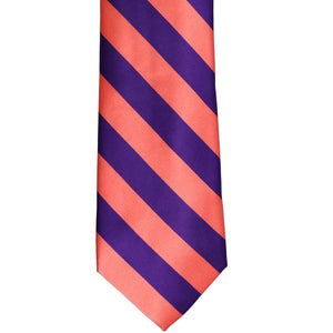The front of a coral and dark purple striped tie, laid out flat