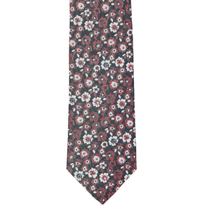 The bottom front of a crimson red and white floral tie on a black background